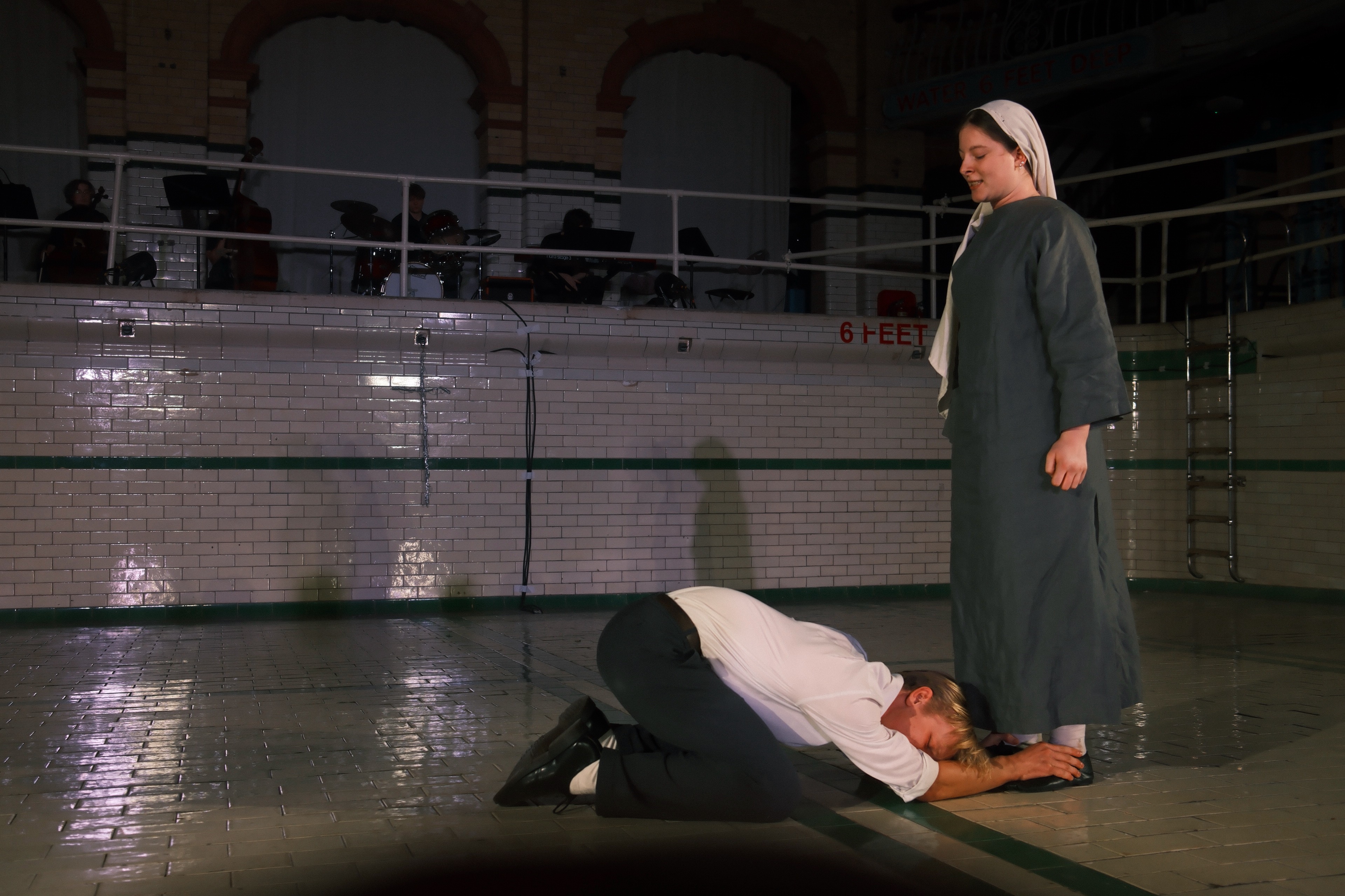 A pleading figure kneeling at Isabella's feet in Measure for Measure.
