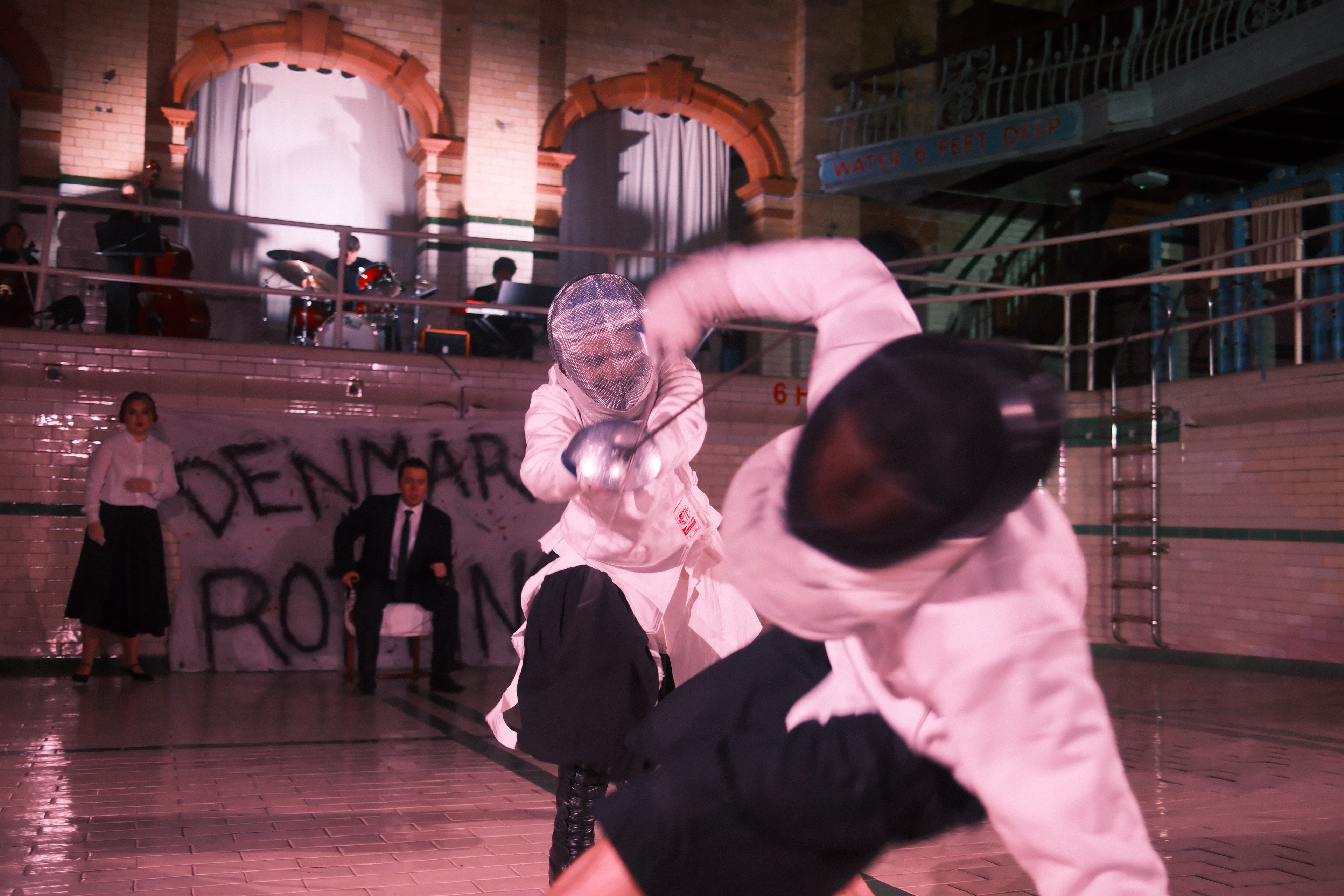 Close-up of the Hamlet duel — masked fencers mid-lunge.