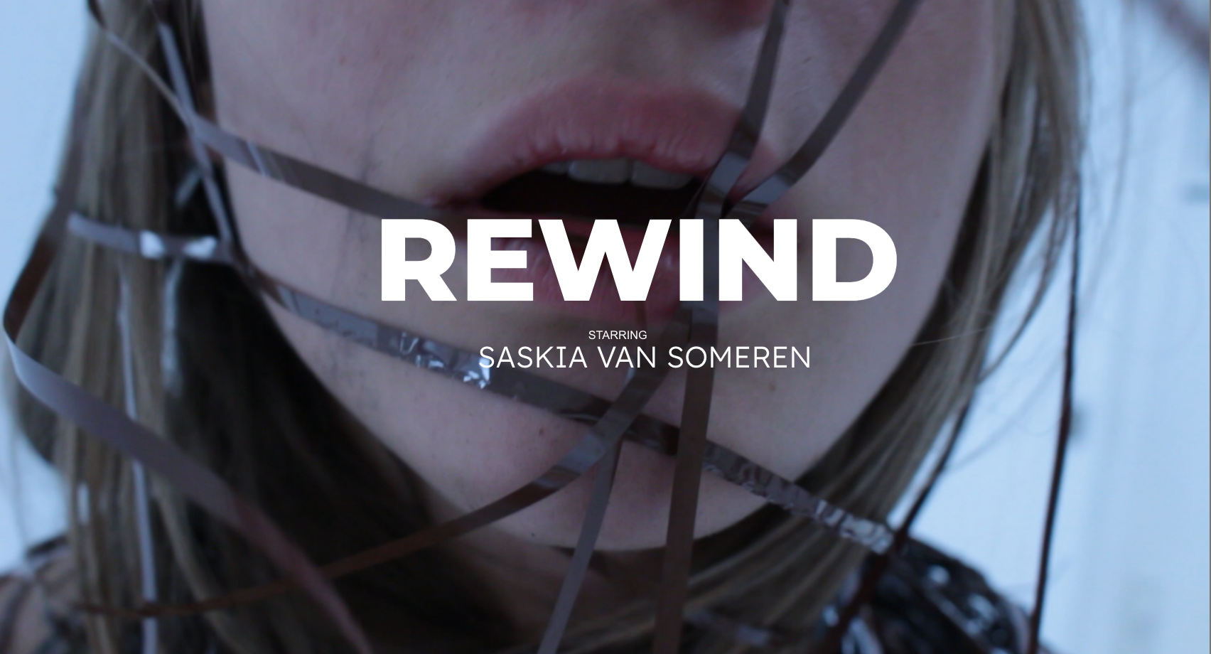Title card from Rewind — mouth wrapped in unspooled cassette tape with the film's title overlaid.