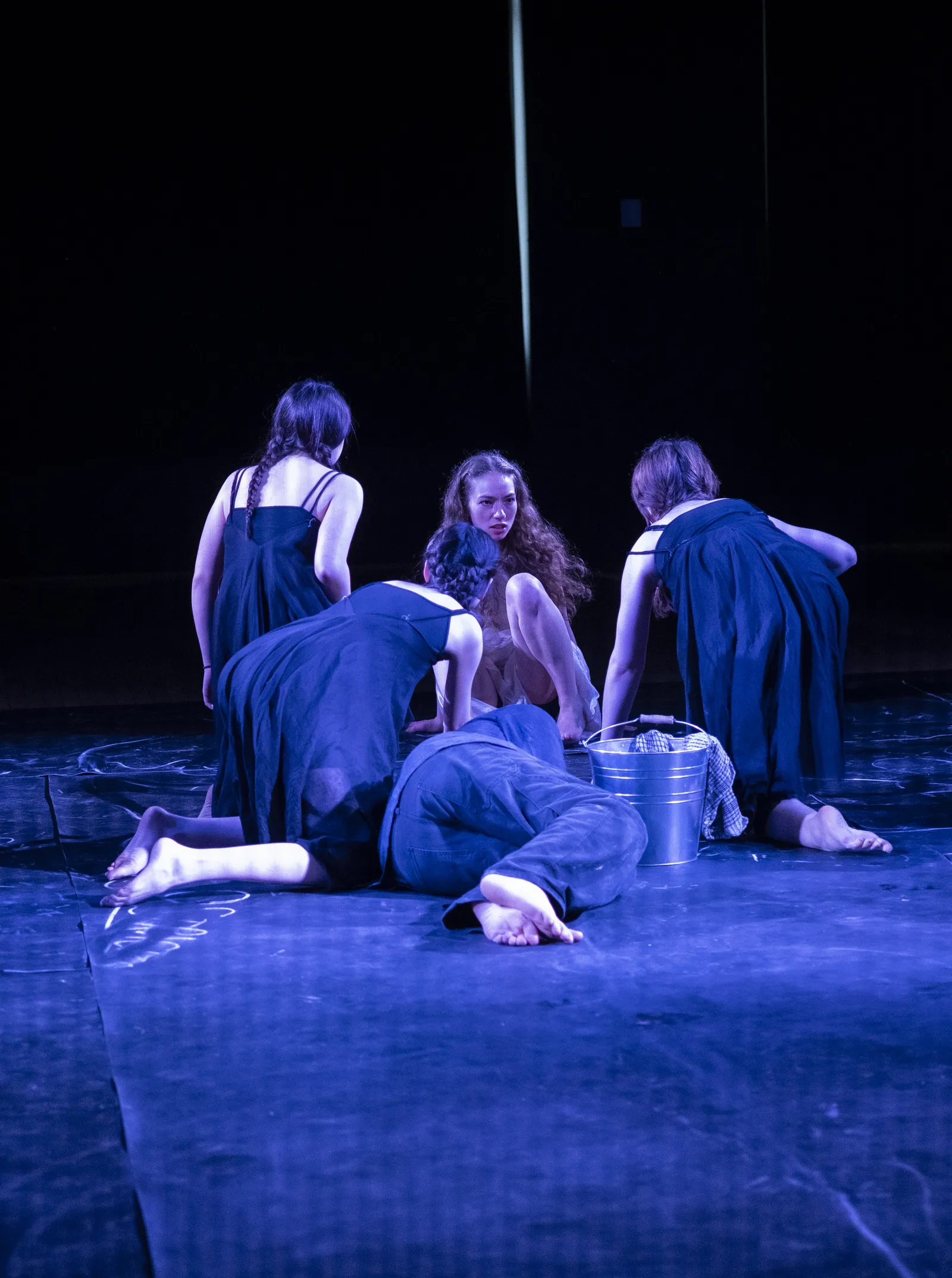 The Stones gathered around a bucket with a figure lying at their feet.