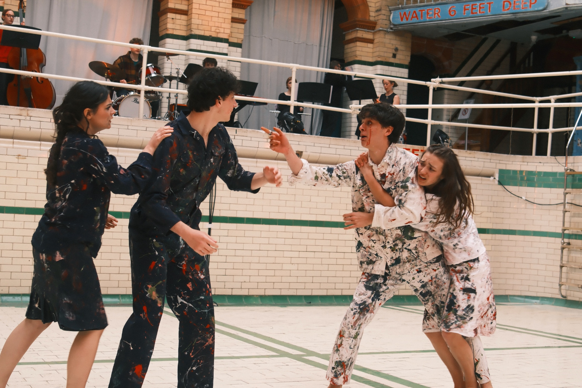 Paint-splattered ensemble mid-confrontation from The Taming of the Shrew.